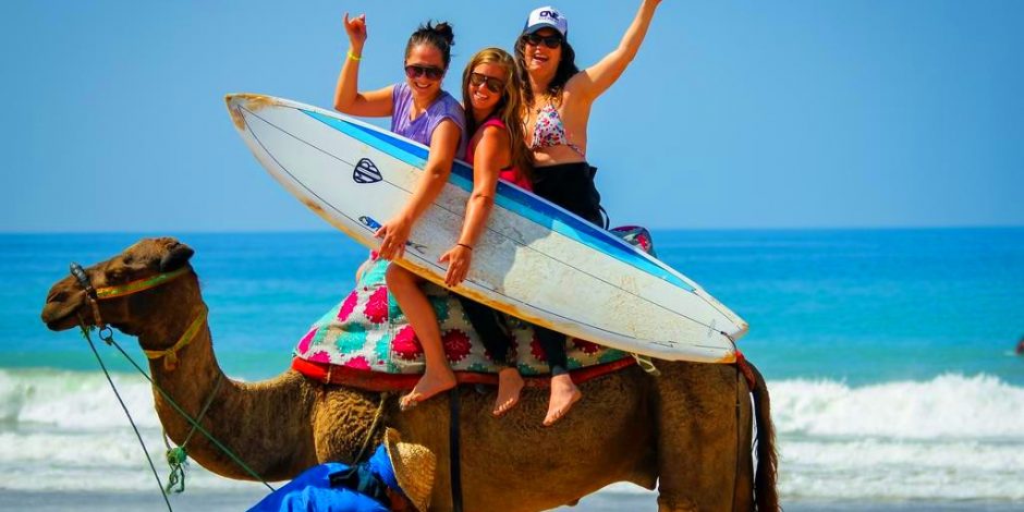 women riding a camel in the beach