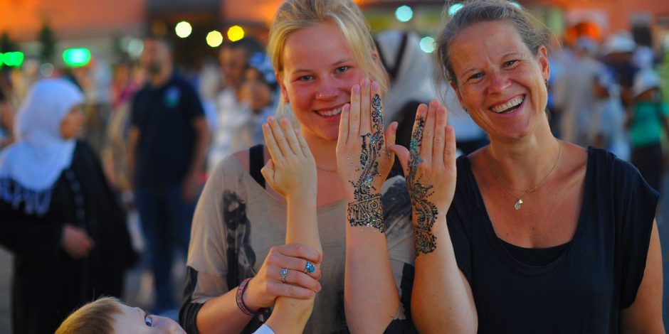 tourists making henna in marrakech square