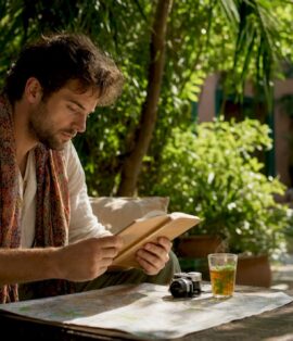 Traveler reviewing Moroccan guidebook outdoors