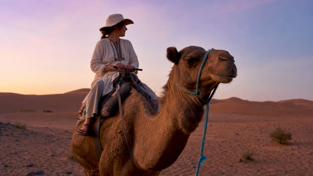 Traveler starting camel trek on Merzouga dunes